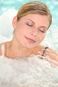 在水疗中心的按摩浴缸里沐浴的美女