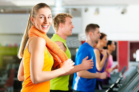 在健身房或健身俱乐部的跑步机上跑步--一群男女为了获得更多的健康而锻炼