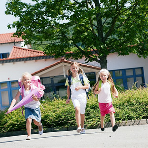 招生简章摄影照片_三个孩子在学校跑步玩得很开心