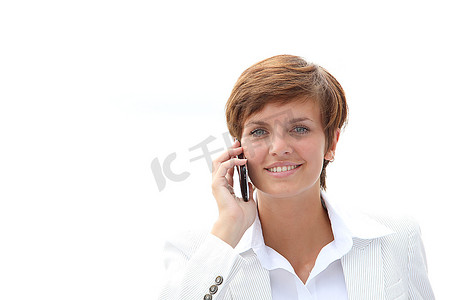 一位微笑的女商人在电话中交谈的特写