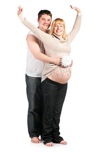 年轻的丈夫抱着鲜花，拥抱着怀孕的妻子
