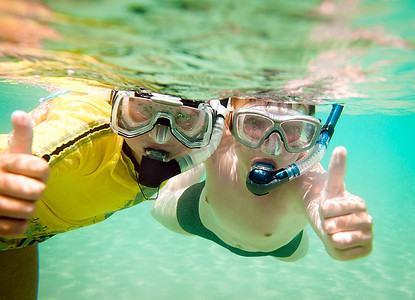 儿童口罩摄影照片_两名戴着口罩的儿童在水中