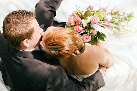 新人拥抱亲吻，新娘手捧一束鲜花