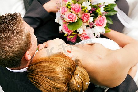 新人拥抱亲吻，新娘手捧一束鲜花