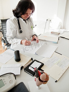 医生在她的办公桌上阅读病人的文件