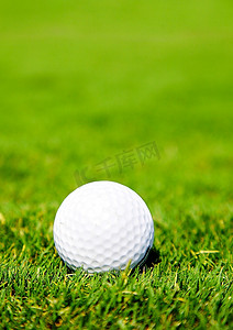 在草地上打高尔夫球。