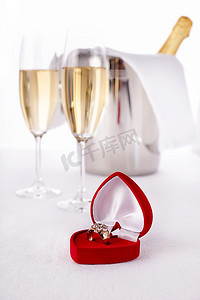 配有香槟和订婚戒指的酒杯，选择性地专注于最近的