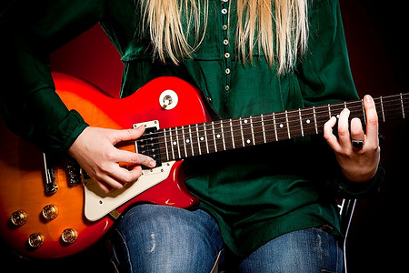女孩与吉他在一个暗红色背景