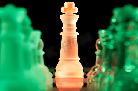 黑暗中，红色国王和一排排绿色玻璃棋子站在棋盘上