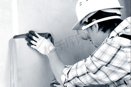 一个工人经常用卷尺量墙