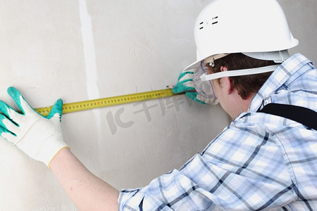 一个工人经常用卷尺量墙