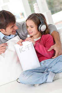 儿童歌曲大赛摄影照片_父亲和女儿在听音乐