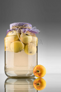 精美果盘摄影照片_一个特写镜头的罐子与保存黄色苹果内。
