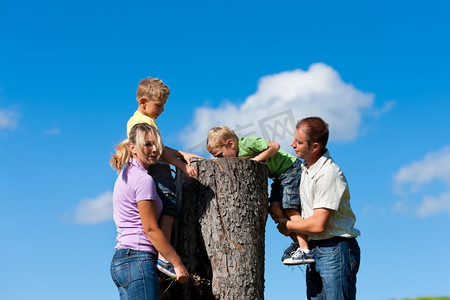 快乐的家庭在夏季远足-他们发现了一个树干