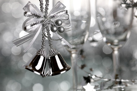 圣诞钟声和银色背景上的两个空酒杯--浅景深