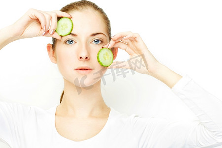 年轻女子，脸上盖着两片黄瓜，清晰的皮肤概念主题