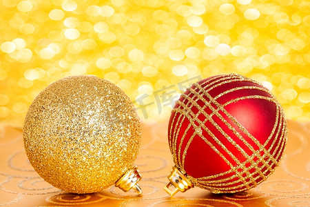 金色灯光背景摄影照片_金色灯光背景上的圣诞树装饰品