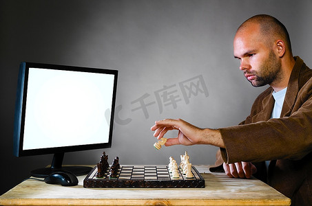 战斗摄影照片_灰色背景下的人类棋手与计算机对决