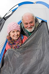 眼睛度假摄影照片_老年夫妇在帐篷入口处，肖像