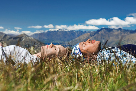 一男一女躺在田野上俯瞰群山