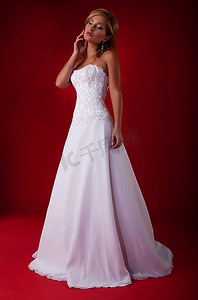红色背景下穿白色长裙的金发新娘时装模特-系列照片