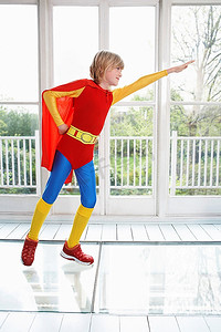小男孩(7-9)穿着超级英雄服装手臂延伸侧视