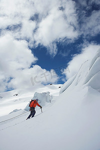 徒步旅行者登上雪山斜坡