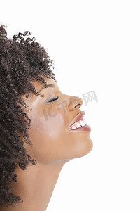 一位非裔美国妇女在灰色背景下闭着眼睛微笑的侧面图