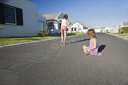 南非开普敦，两个女孩在街上玩跳房子