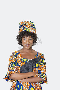 穿着非洲印花服装的年轻女子双臂交叉站在灰色背景上的肖像