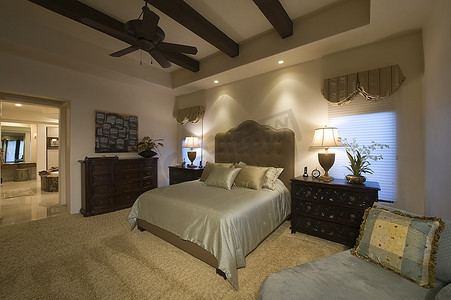 棕榈泉带梁天花板卧室的双人床上有真丝床罩