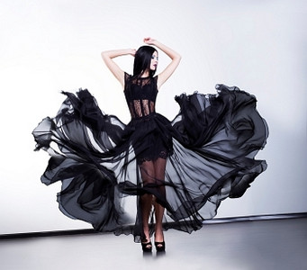 穿着飘逸的黑色透明连衣裙的神奇时尚女性