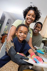 母亲、父亲和儿子在家里的厨房里洗盘子
