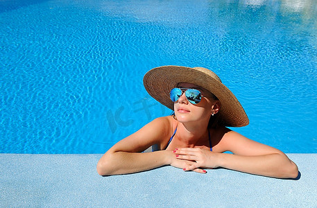 晒水摄影照片_戴着帽子的女人在游泳池里放松