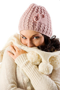 防寒帽子摄影照片_可爱的深色皮肤遮盖着一张防寒的脸，她的羊毛衫在镜头前看着