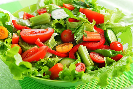绿色餐巾上的白色沙拉配新鲜蔬菜