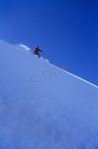 滑雪者从陡峭的雪坡上滑下