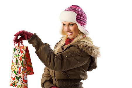 漂亮的金发女孩穿着冬装，戴着帽子和手套送圣诞礼物
