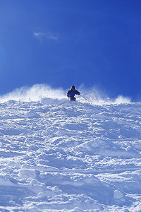 滑雪者从陡峭的雪坡上滑下