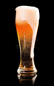 警示反光条摄影照片_溢出来的一杯新鲜啤酒，黑底，有反光