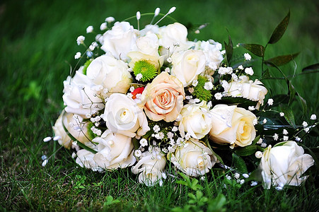草地上的白色和粉色玫瑰组成的婚礼花束
