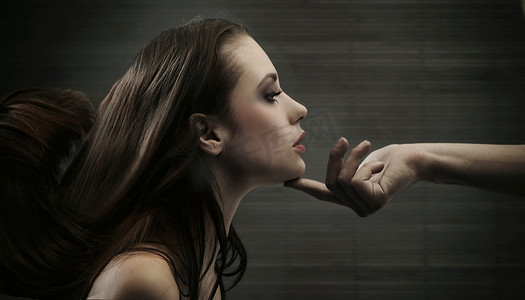 一只手握着一个女人的头的概念性表示图