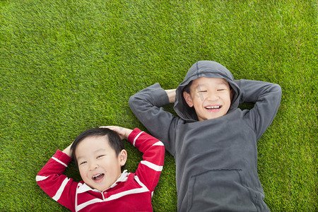 学前教育摄影照片_两兄弟躺在公园的草地上