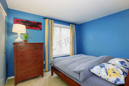带棕色梳妆台的小卧室的蓝色内饰 