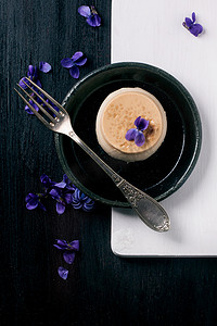 焦糖 pannacotta 与紫罗兰色的花朵