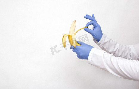 Dotkor手里拿着香蕉和剥皮 外科手术的概念，用来解剖男性包皮的狂暴、包皮的割除、阴道炎、复制空间