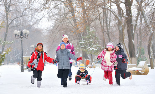 群儿童和母亲在冬天的时候在雪地上玩