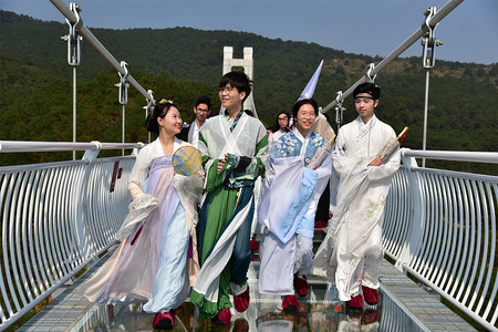 Models dressed in Hanfu or traditional Chinese costume pose on a glass-bottomed bridge in Foshan city, south China's Guangdong province, 30 January 2019.  