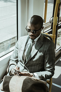 年轻的非洲裔美国商人坐火车听音乐