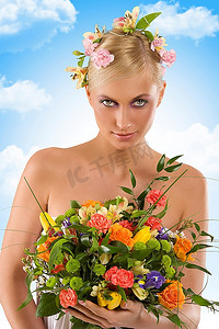 年轻的金发女子头上戴着鲜花，胳膊上抱着一束彩色的花束